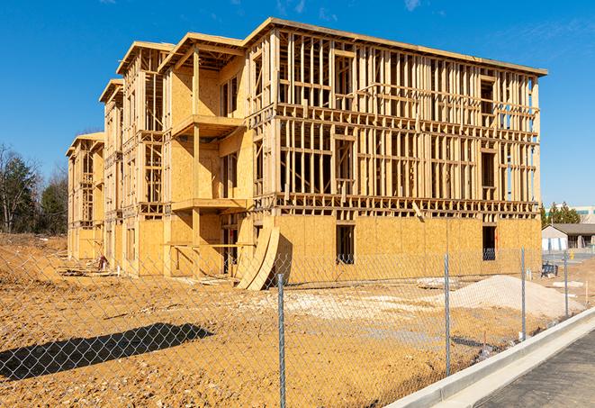 a temporary chain link fence in front of a building under construction, ensuring public safety in Combes, TX